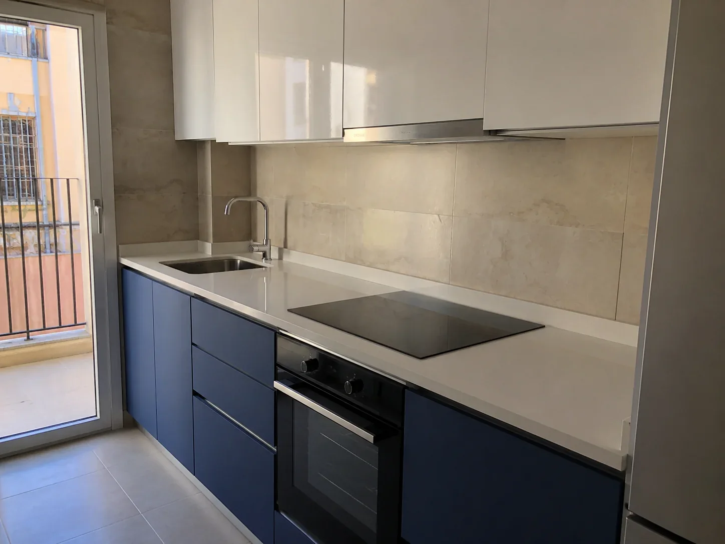 Cocina azul reformada con encimera clara