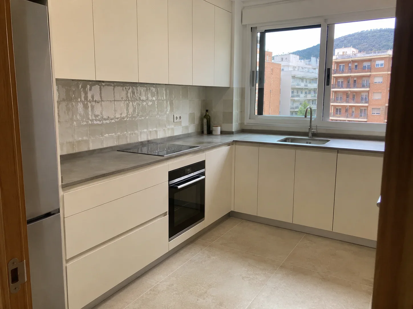 Cocina blanca reformada con distribución en L