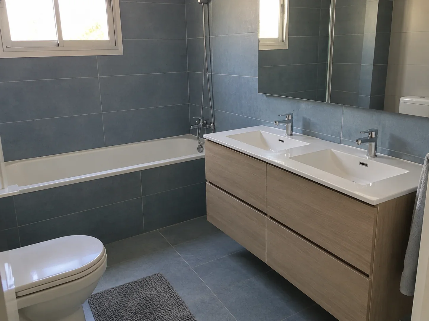 Baño reformado con doble lavabo y bañera