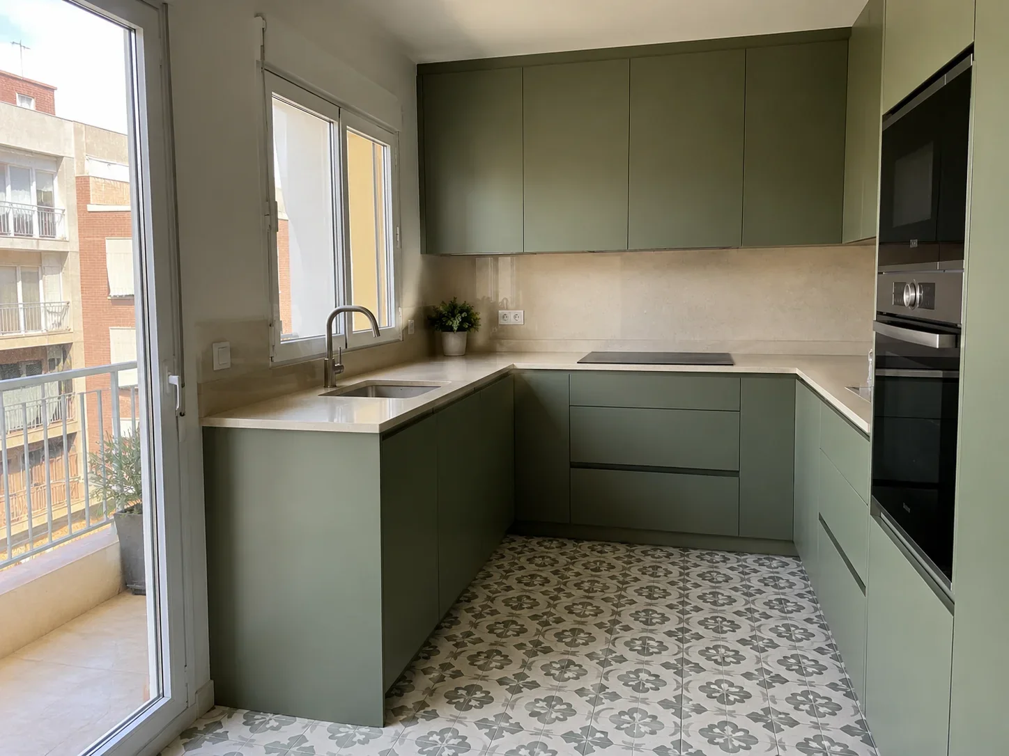 Cocina verde reformada con distribución en L